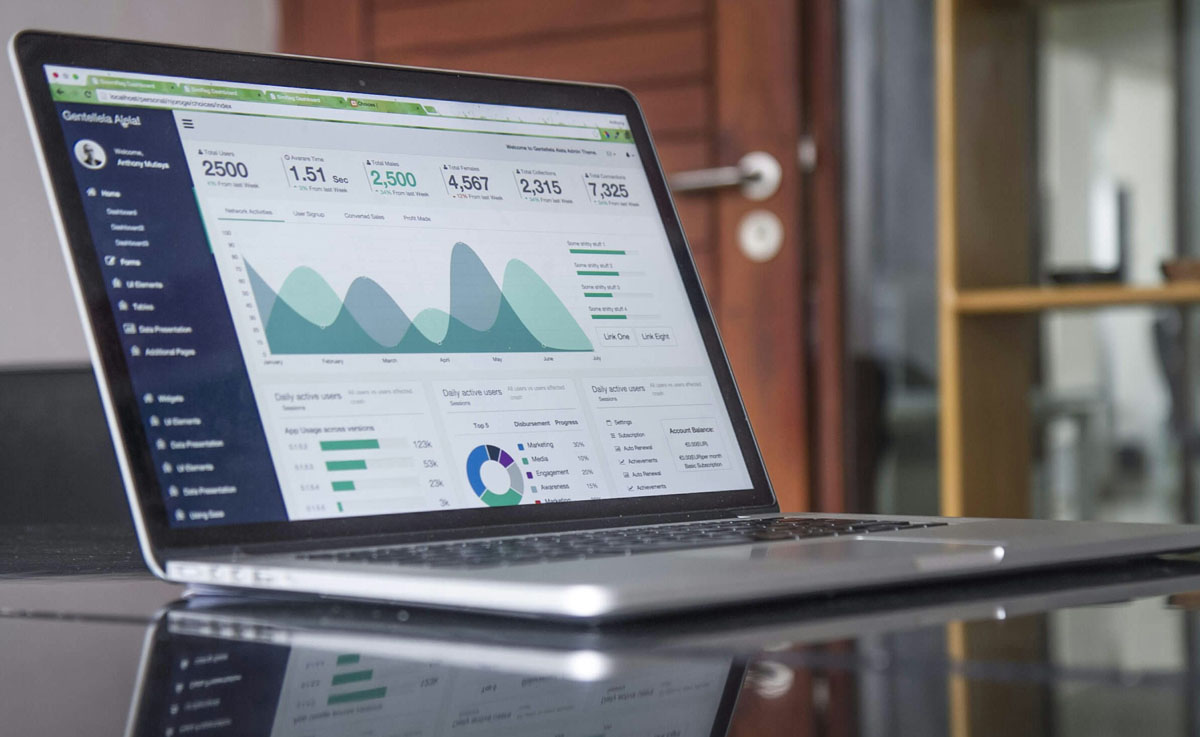 A laptop is open to a webpage reflecting B2B SEO data and graphs in green and grey