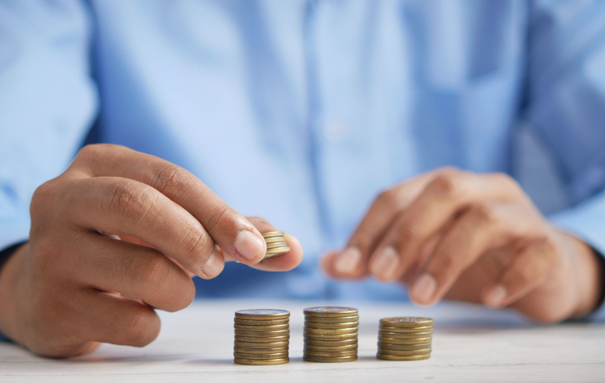 Man stacking coins wondering how much does a website redesign cost?